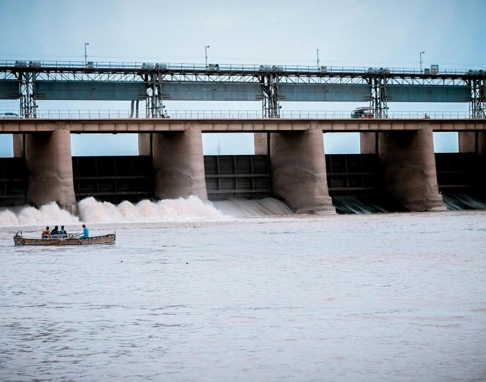 Hydroelectric dam in Jamshoro, Sindh with boat and people on Indus River.